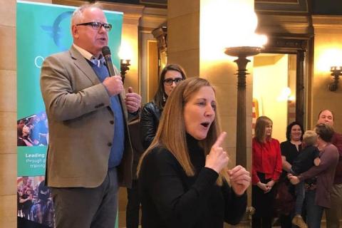 With the aid of a sign-language interpreter in the foreground, Walz speaks to about 100 LGBTQ activists and their supporters. 