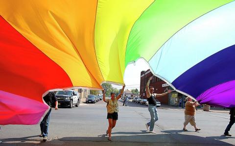 Participants in the the 2009 Duluth-Superior Pride parade in Superior display a 37-foot by 74-foot rainbow flag