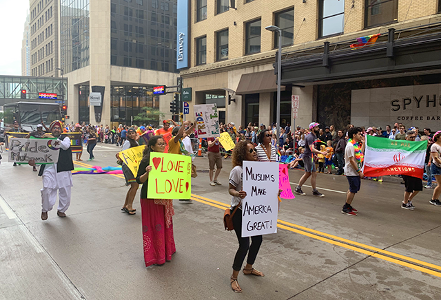 A number of marchers display signs with slogans such as "Love is love," "Muslims make America great!" and "Stop Iranian sanctions."